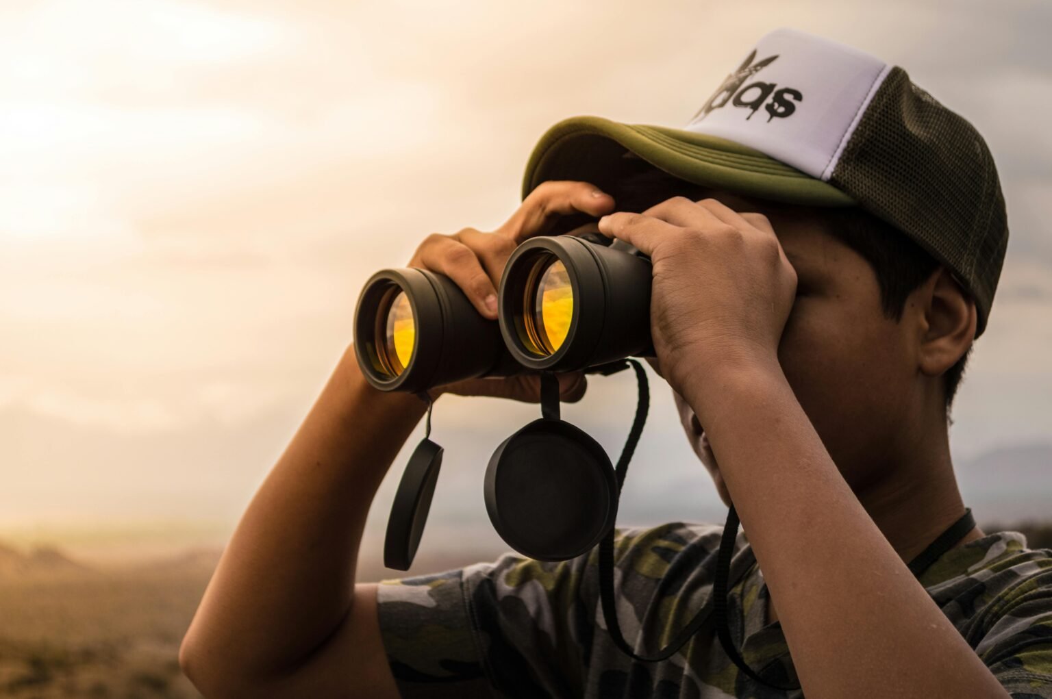A person looking through premium binoculars at a stunning scenic landscape